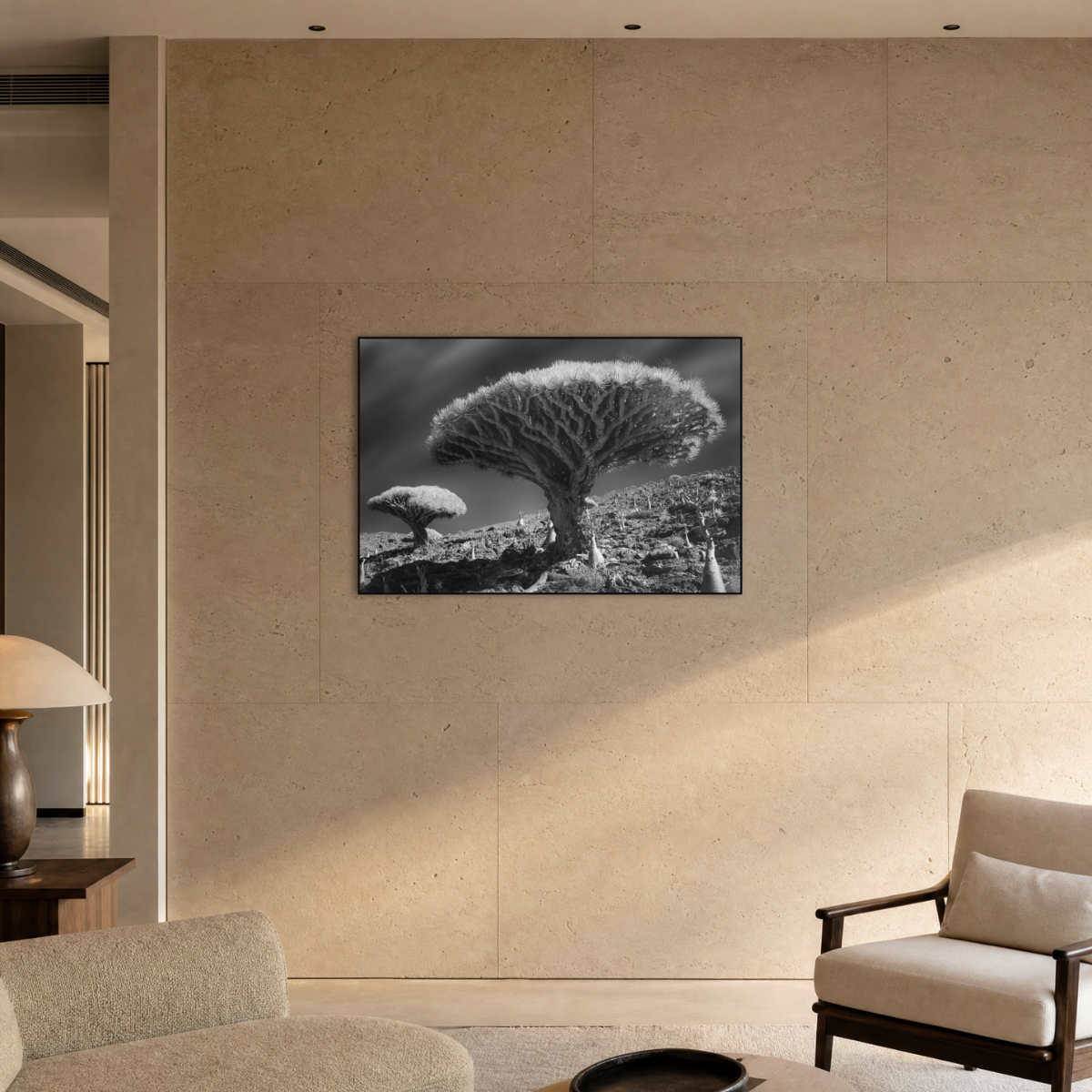 Gito.Art - Exclusive Art Print - Photography by Delyan Markov
A black and white landscape wall art print featuring a dramatic tree in a rocky terrain, displayed on a beige stone wall in a modern, softly lit living room.