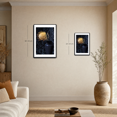 Two framed artworks on a beige wall with a sofa and decorative items in the foreground. ~ Pincushion Protea ~ Fine Art Photography by Ivo Titzin ~ Luxury Wall Art by Gito ~ Limited edition
