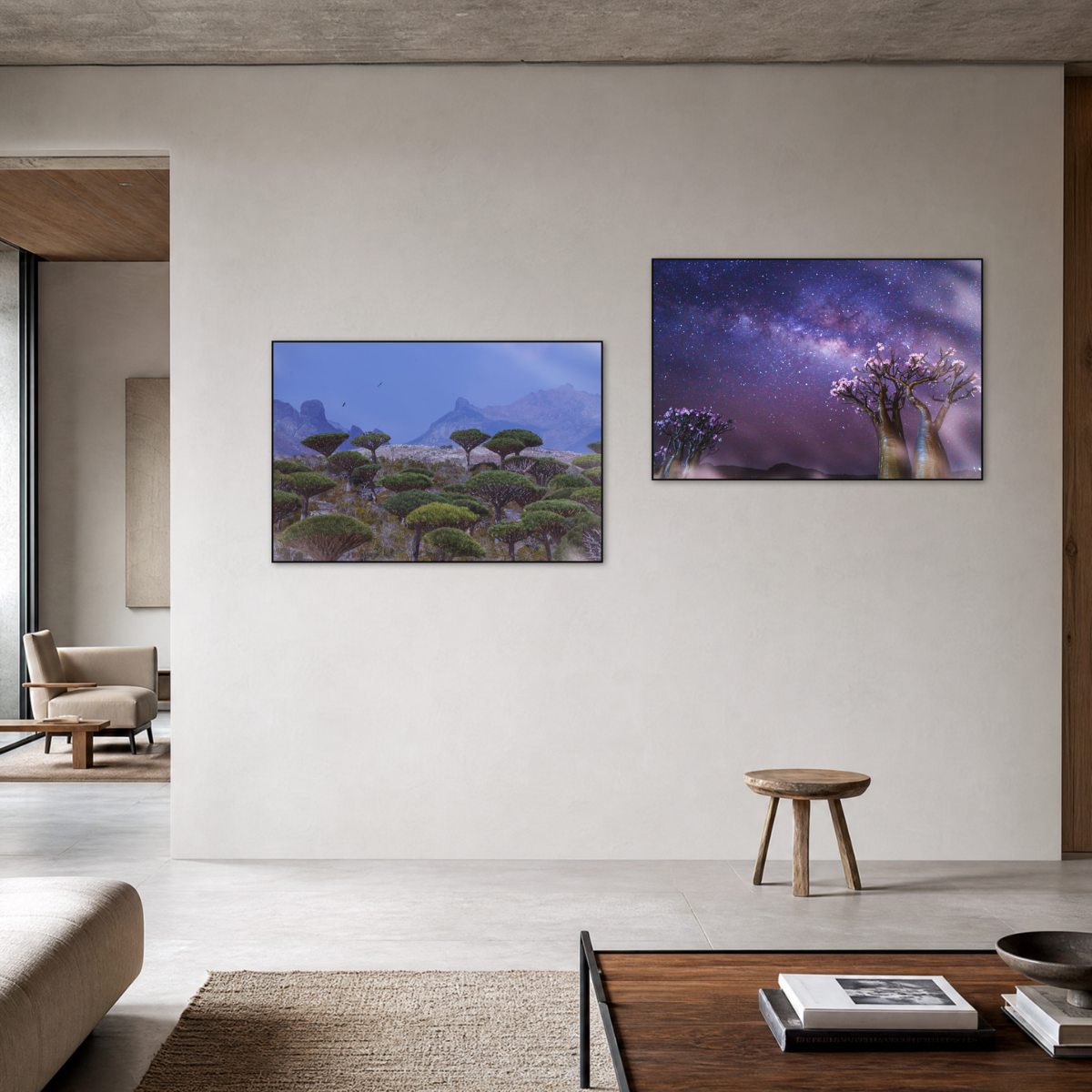 Gito.Art - Exclusive Art Print - Photography by Delyan Markov
Gito.Art - Exclusive Art Print - Photography by Delyan Markov
Two framed landscape art prints displayed on a beige wall in a modern, minimalist living room. The left print shows a blue-toned landscape with trees and mountains, and the right print shows a purple-toned night sky with stars and flowering trees.