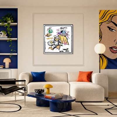 Gito Fine Art Print - Art Vladi Vl Comics - Tigers
A framed pop-art style poster featuring a cartoon astronaut and text hangs on a beige wall above a cream sectional sofa in a modern living room. A large portion of a yellow-and-blue comic-style face is visible on the right side of the wall.